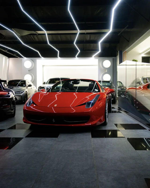 Red Ferrari 458 Spider facing forward under showroom lights