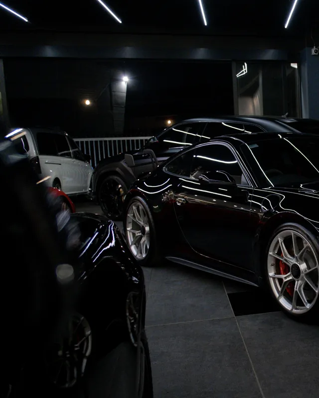 Black Porsche 911 GT3 in a dimly lit showroom