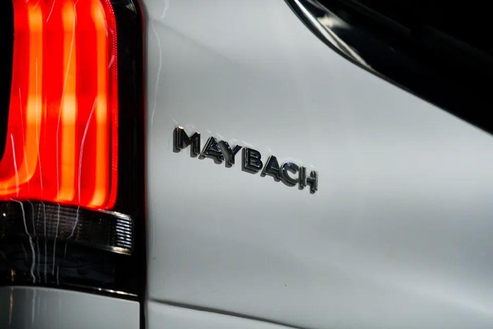 Maybach lettering beside a red tail light on the rear of a white van