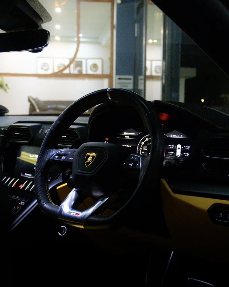 Lamborghini Urus steering wheel with the bull badge, digital instrument cluster and yellow trim