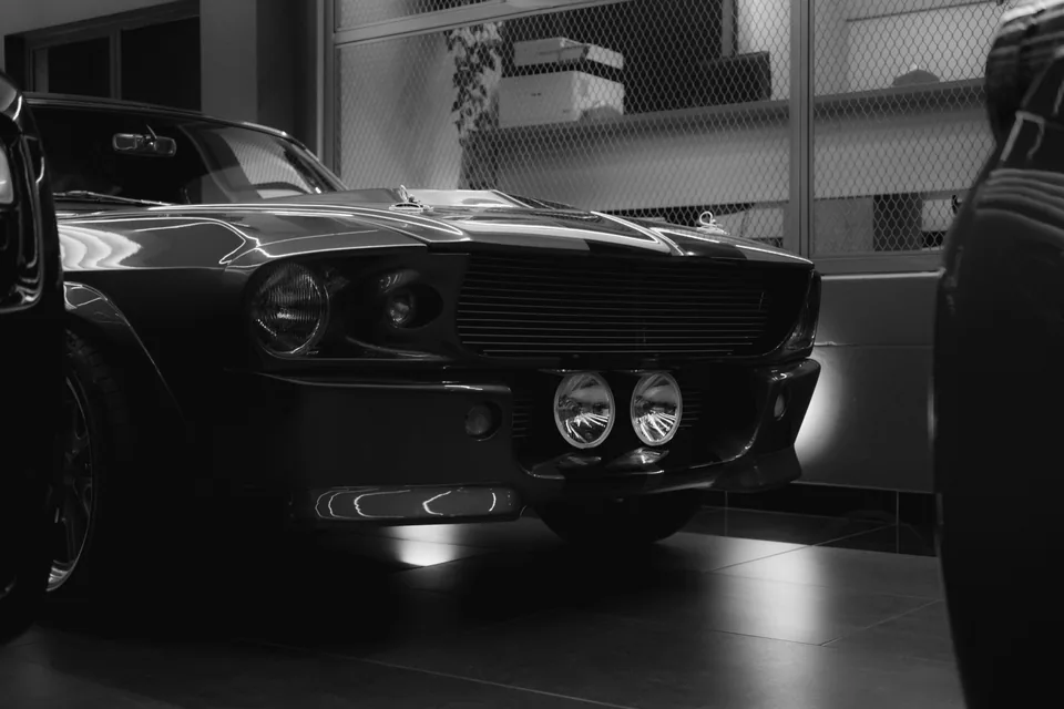 Black-and-white photograph of a 1967 Ford Mustang Shelby GT500 front three-quarter view with twin centre driving lights